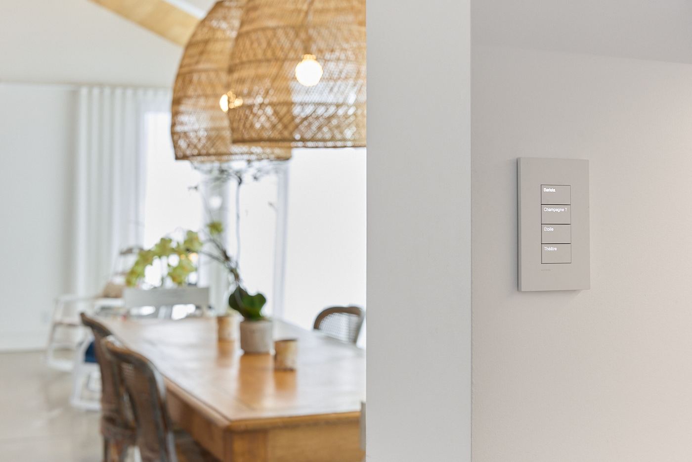Discreet white Lutron keypad in a bright dining room