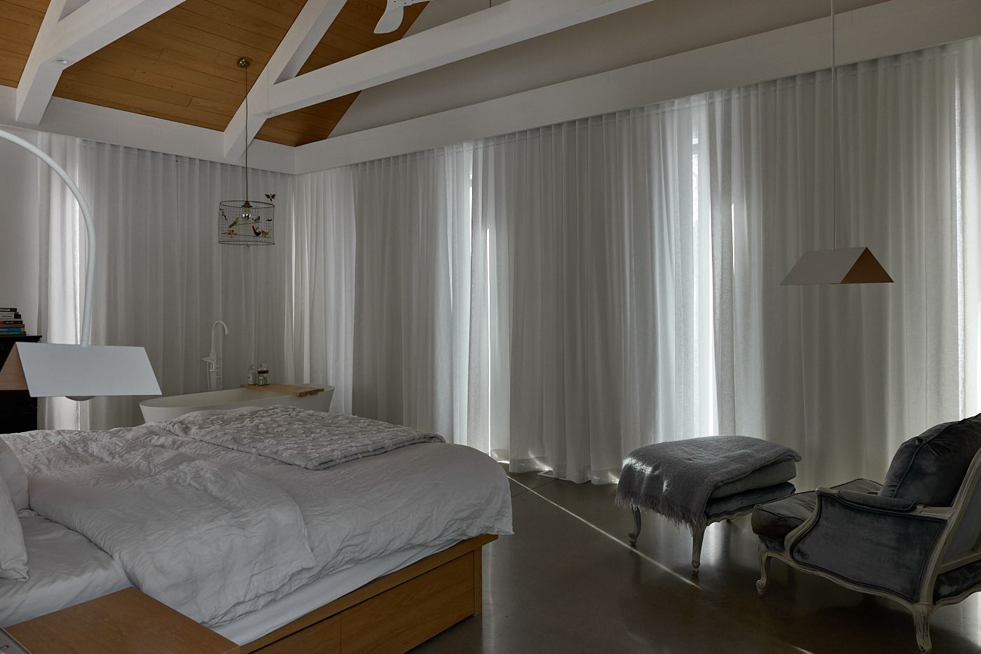 Chambre avec toiles motorisées Lutron à demi baissées devant une vue sur les montagnes, Mansonville
