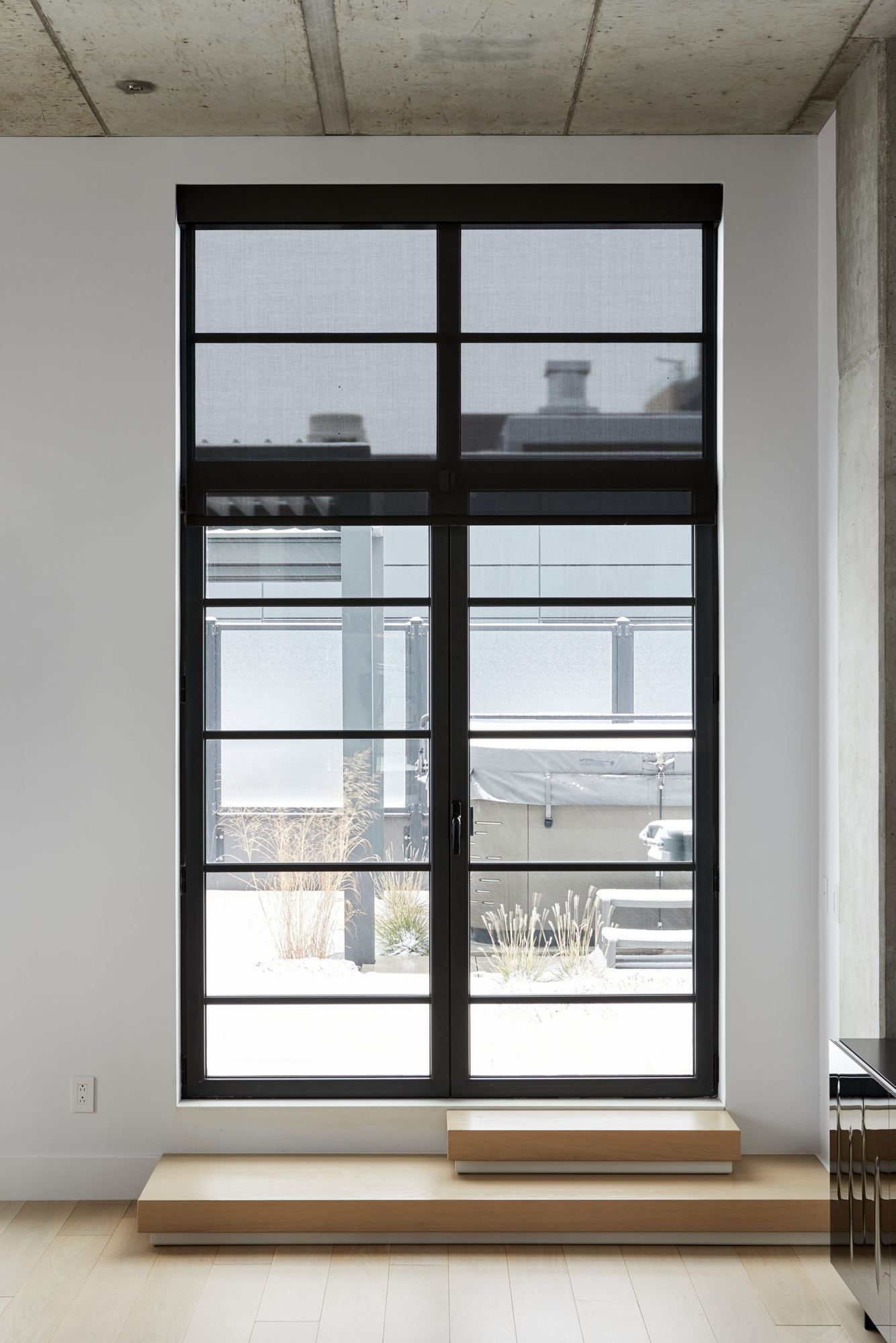 Fenêtre d'un penthouse de Griffintown avec toile motorisée et boîtier peint de la couleur du cadre